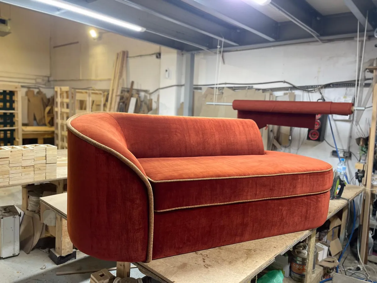 Chaise longue de terciopelo rojo recién tapizada en el taller