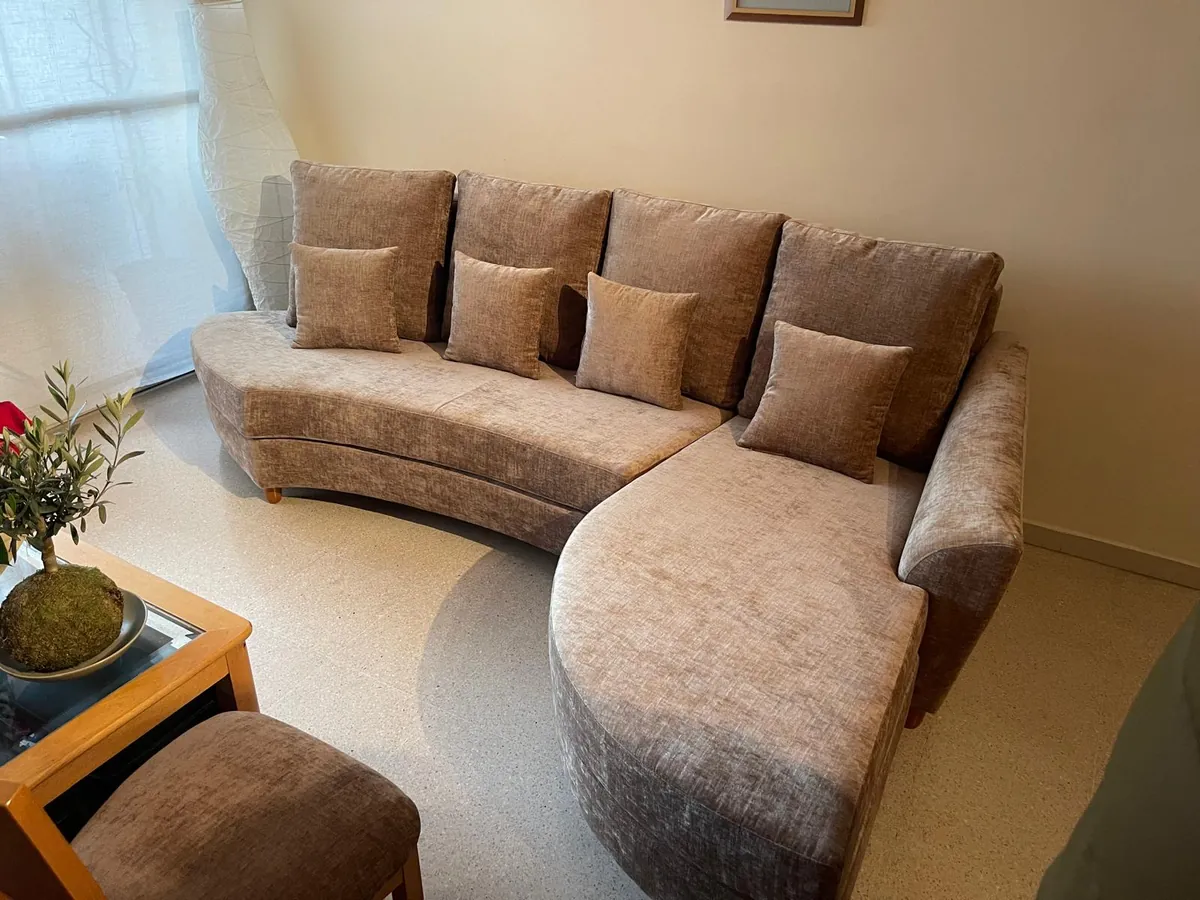 Sofá curvo con chaise longue en un salón