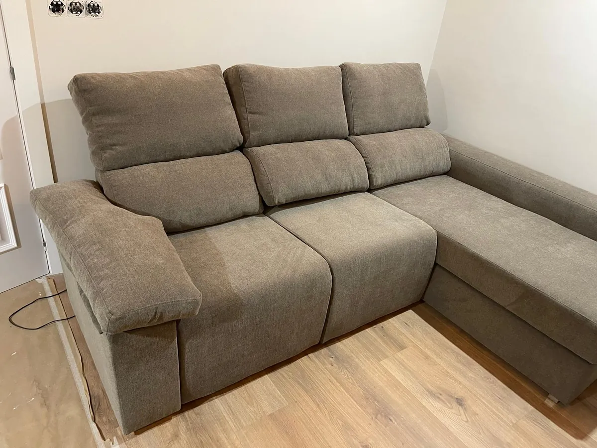 Sofá chaise longue marrón en una casa